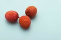 Three lychee fruits lie on a turquoise blue background Royalty Free Stock Photo