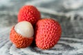 Three lychee fruits on wooden background close