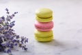 Three macarons and bouquet lavender on white natural marble table