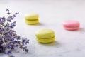 Three macarons and bouquet lavender on white natural marble table