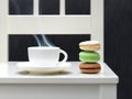 Three macaroon biscuits and hot drink