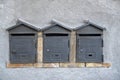 Three mailboxes in the shape of houses built into a wall closeup Royalty Free Stock Photo