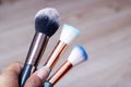 Three makeup brushes on gray background closeup