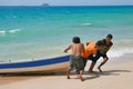 Three Malaysian man handling their jetboat on tropical beach Royalty Free Stock Photo