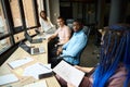 Three male and female colleagues listening to their female teamlead