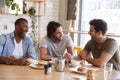 Three Male Friends Meeting For Lunch In Coffee Shop Royalty Free Stock Photo