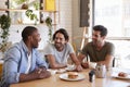 Three Male Friends Meeting For Lunch In Coffee Shop Royalty Free Stock Photo