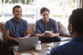 Three male friends talking over coffee at a coffee shop Royalty Free Stock Photo