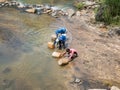 Three Man Filling Water Into Jerry Can in the River Royalty Free Stock Photo