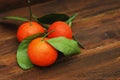 Three Mandarins with Green Leaves on a Rustic Wooden Table. Isolated. view from Above. Royalty Free Stock Photo