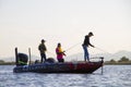 Three men fishing on a boat on the lake Royalty Free Stock Photo