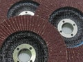 Three maroon (grinding wheels) abrasive flap discs overlap on a white background. Royalty Free Stock Photo