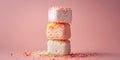 Three marshmallows stacked on top of each other, with sprinkles on top and scattered on the pink background Royalty Free Stock Photo
