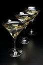 Three Martini drinks with olives isolated on black table Royalty Free Stock Photo