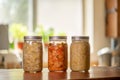 Three mason jars with kimchi and sauerkraut on kitchen counter Royalty Free Stock Photo