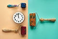 Three massager with red, orange and blue drums, metal needles lie near the clock on a yellow-green surface. top view. Thematic and