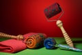 Three masseurs with orange, blue and red drums, metallic needles on a red background lie near the towel. Subject and promotional