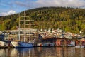 Bergen harbor with schooner, picturesque town and forested hill, Norway