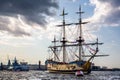 Three masted yellow wooden Tall Ship on the River Neva with Peter and Paul Cathedral in background in St Petersburg, Russia