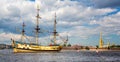 Three masted yellow wooden Tall Ship on the River Neva with Peter and Paul Cathedral in background in St Petersburg, Russia