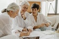 Three mature businesswomen talking and smiling while working in office together. Royalty Free Stock Photo