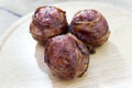 Three meatballs and covered with bacon on cutting board Royalty Free Stock Photo