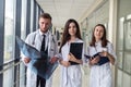 Three medical intern looking through x-ray image of lungs for viral pneumonia of Covid-19 patient in clinic Royalty Free Stock Photo