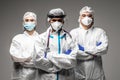 Three medical healthcare workers in biohazard protective tools standing isolated on gray background. Ready to fight with covid19 Royalty Free Stock Photo