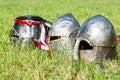 Three medieval knight`s helmets on the grass