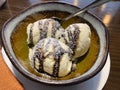 Three melting chocolate ice cream balls in brown ceramic bowl on table