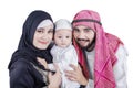 Three members of Arabic family smiling at camera