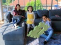 Three members of mixed races family, father, mother and kid daughter live together in home living room. Girl throwing toy with dad Royalty Free Stock Photo