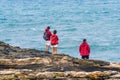 Three members of the same family, father, mother and eldest son dressed in the same red jacket, from the top of a cliff