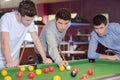 Three men around pool table Royalty Free Stock Photo