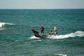 Three men on a boat sail from the open sea towards the shoreline, one giving directions while another steers