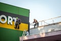 Three men, construction workers, wearing security equipment, fixing and renovating a building on a rooftop