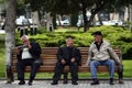 Three men in conversation on a bench in Baku, Azerbaijan