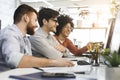 Three men enjoying good coding job on computer at modern office Royalty Free Stock Photo