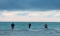 Three Men Fishing in Ocean Royalty Free Stock Photo