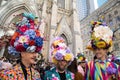 Three men in floral hats and brightly colored costumes in the Easter Bonnet Parade