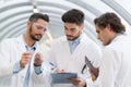 Three men in labcoats in discussion Royalty Free Stock Photo