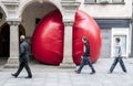 Three men look at Kurt Perschke's giant Red Ball