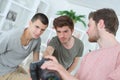 Three men looking at photo on camera display