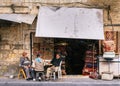 Three men relax next to a carpet market in the Old Town of Jaffa in Tel Aviv, Israel