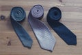 Three men`s tie rolled into a roll on a wooden background Royalty Free Stock Photo