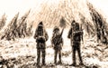 Three men stands at the entrance to the cave. Sepia color.