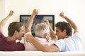 Three Men Watching Widescreen TV At Home Royalty Free Stock Photo