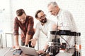 Three men are working on preparing a 3d printer for printing. One of them explains the rest of the subtlety the print. Royalty Free Stock Photo