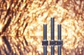 Three metal bolts with fancy shiny gold background full of sparks out of focus.
