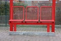 Red metal seats in a row at the bus stop